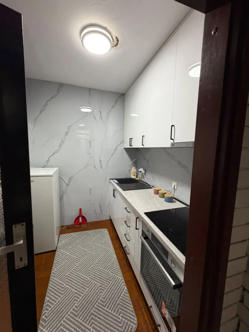 Smaller equipped kitchen with white elements.