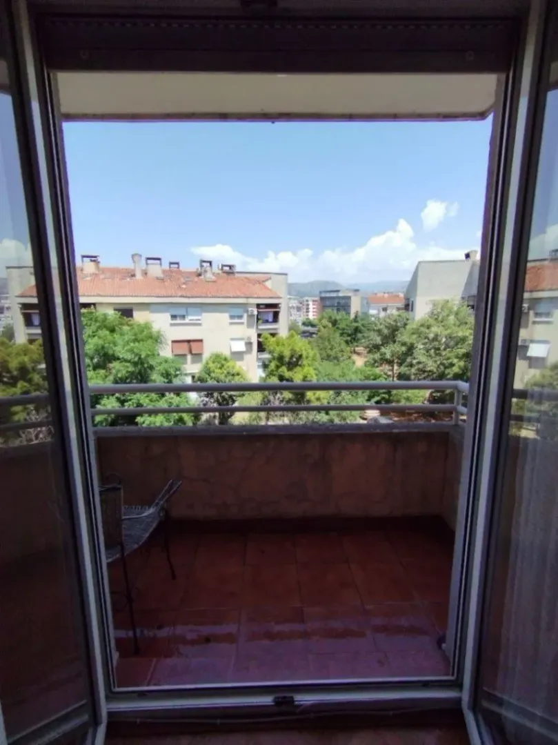 View from the balcony overlooking surrounding buildings and greenery.