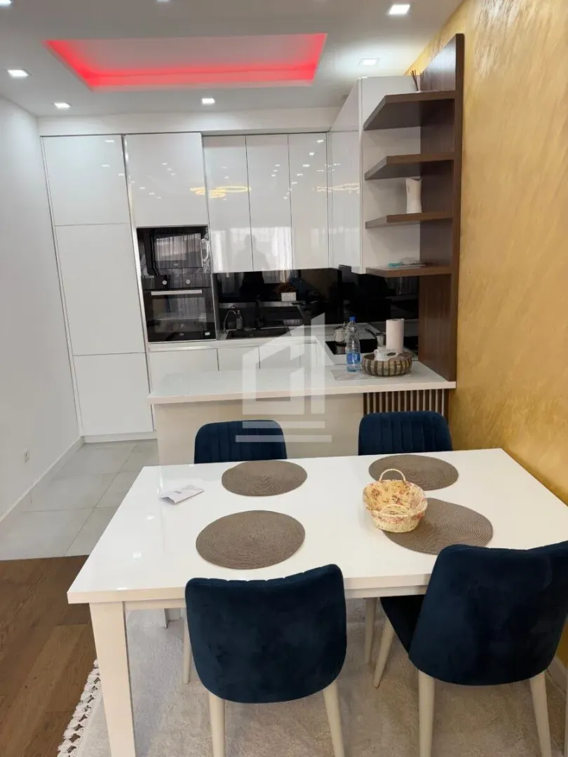 Kitchen with dining area equipped with white cabinetry and a modern dining table.