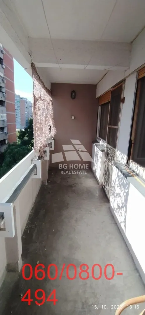 Dugačka natkrivena terasa sa pogledom na susedne zgrade.