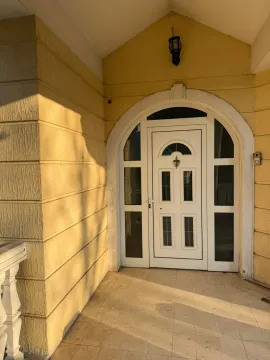 An entrance door with an arched frame on a yellow house facade. - image 6