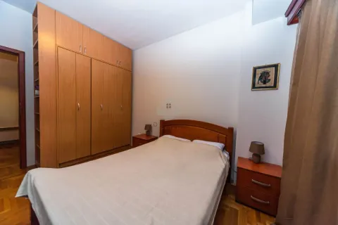 Spavaća soba sa bračnim krevetom, drvenim ormarom i noćnim stočićima. - image 5