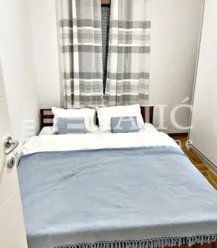 Bedroom with a double bed, a white wardrobe, and a window with curtains. - image 7