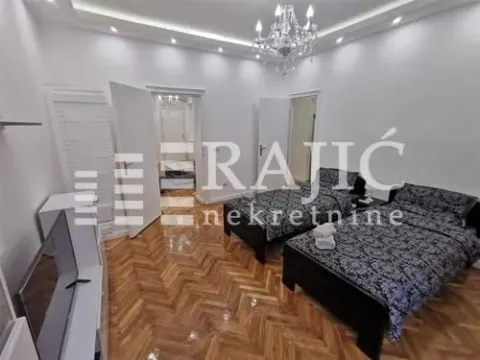 Bedroom with two beds and parquet flooring. - image 7