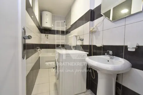 Small bathroom with a sink, washing machine, and bathtub. - image 8