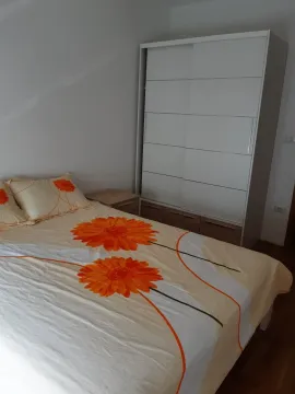 A bedroom with a double bed and a large white wardrobe. - image 4