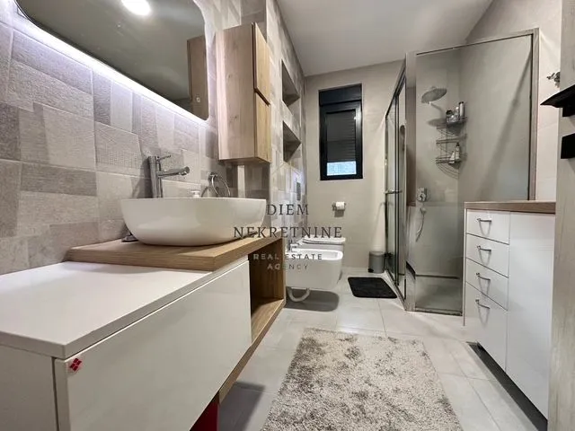 Modern and clean bathroom with a washbasin, shower cabin, and sanitary fixtures.