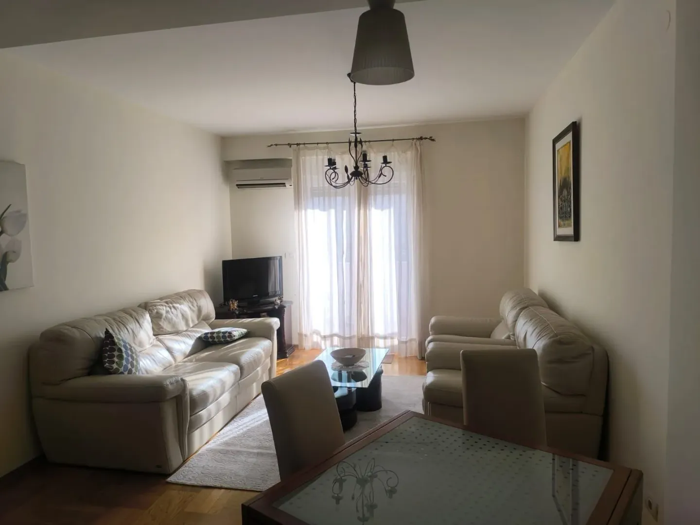 Spacious living room with a sofa set, dining table, and access to the terrace.