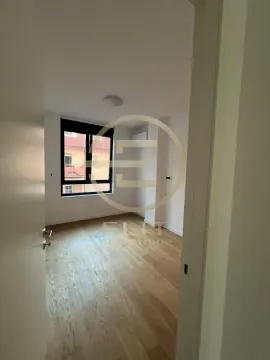 View from the hallway into an empty room with wooden flooring and a window. - image 5