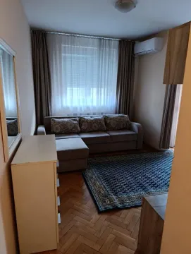 Small living room with a sectional sofa, rug, and window with curtains. - image 11