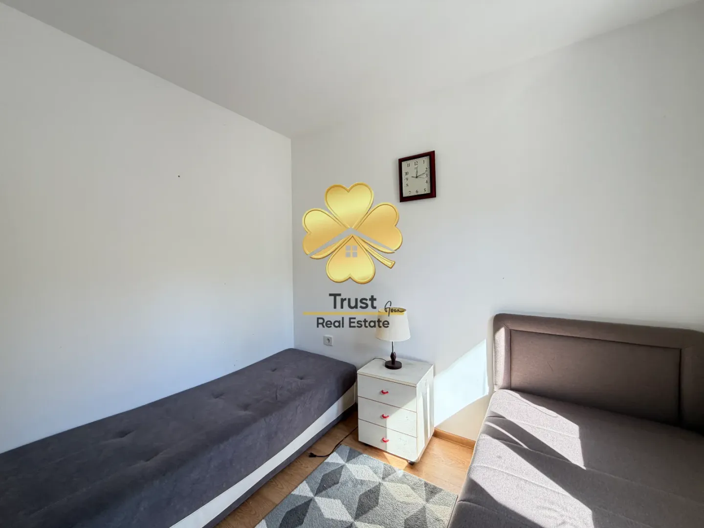 Smaller bedroom with two beds and a nightstand.