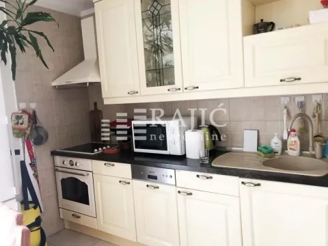 Equipped kitchen with white cabinets and built-in appliances. - image 4