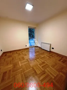 Prazna soba sa drvenim parketom i vratima koja vode na terasu. - image 10