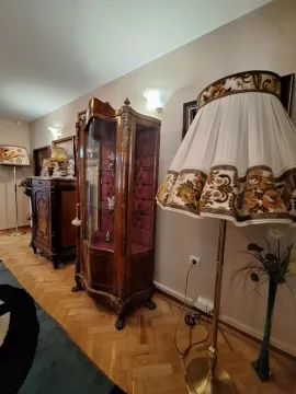 Living room with antique wooden furniture and decorative lamps. - image 5