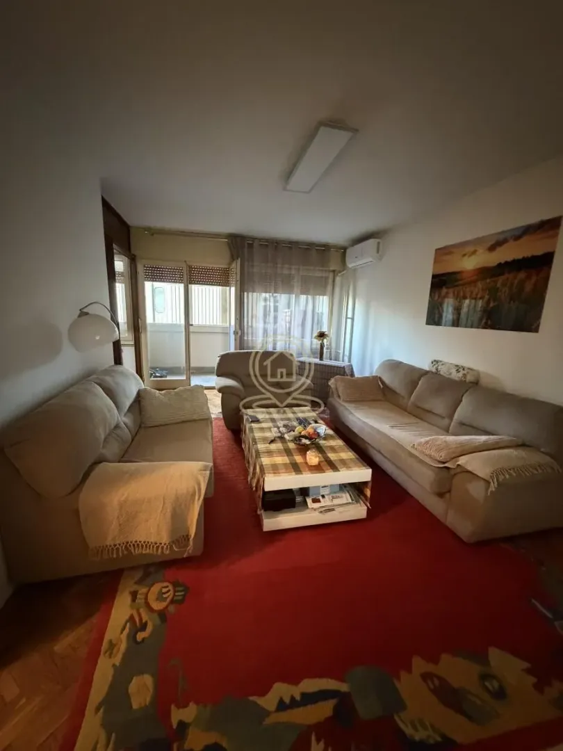 Dnevna soba sa garniturom za sedenje i stočićem.
