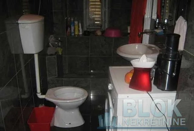 Bathroom with a toilet, sink, and washing machine.