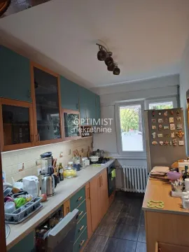 Smaller kitchen with wooden cabinets and built-in appliances. - image 14