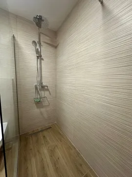 Modern walk-in shower with tile flooring and wall-mounted fixtures. - image 10