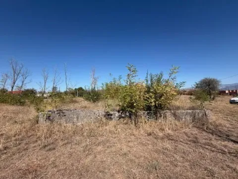 Pogled na plac sa rastinjem i ostacima temelja. - image 2
