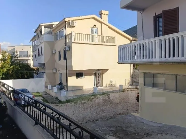 Pogled na eksterijer kuće sa dvorištem i terasom.