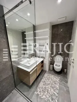 Modern bathroom with a washbasin, walk-in shower, and toilet. - image 13