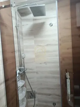 Shower cabin with a shower set and wood-pattern tiles. - image 14