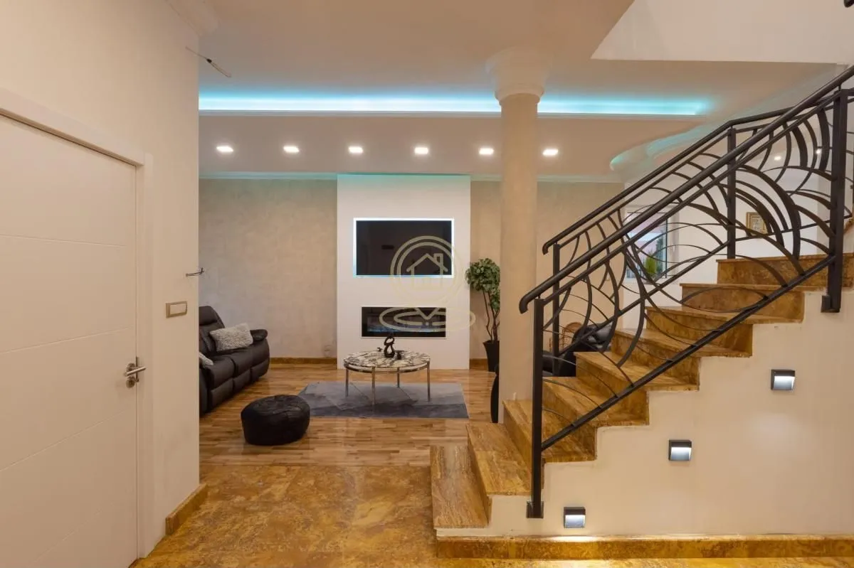 Living room with sofa, fireplace, and staircase.