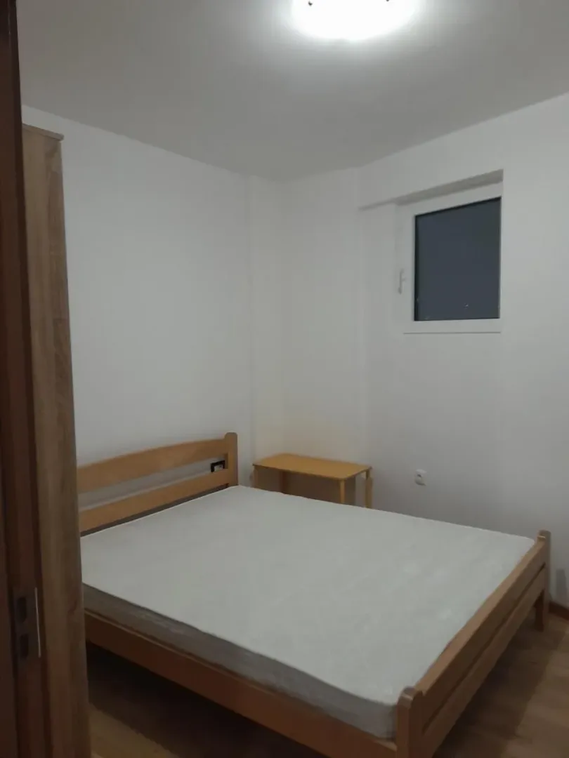 Simply furnished bedroom with a wooden bed.