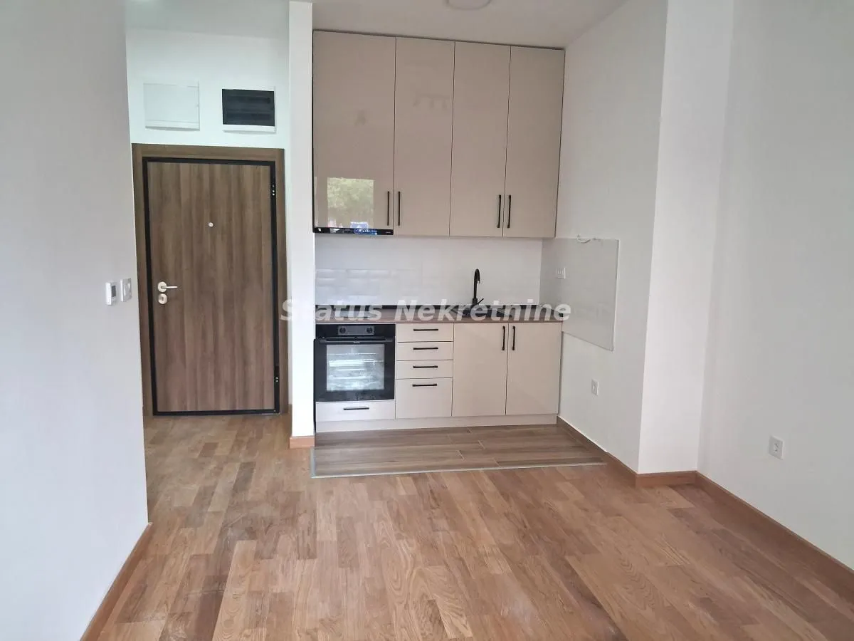 Small kitchen with fitted cabinets and wooden flooring.