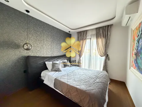 Furnished bedroom with a double bed, dark accent wall, and curtains. - image 11