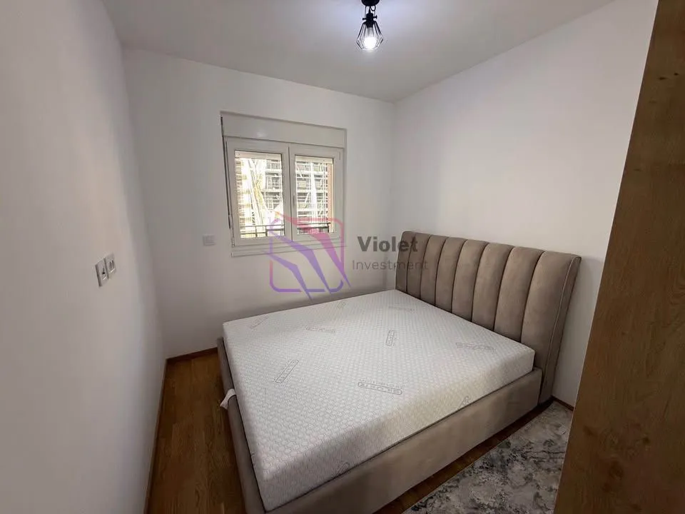 Furnished bedroom with a double bed and a window.