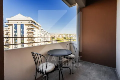 Covered balcony with a small table and two chairs and a city view. - image 2