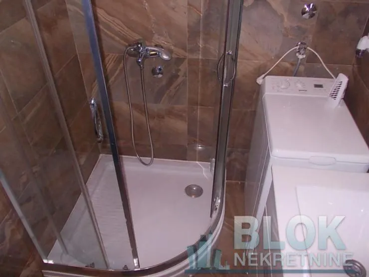 Bathroom with a shower cabin and a washing machine.