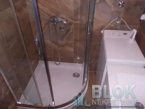 Bathroom with a shower cabin and a washing machine. - image 5