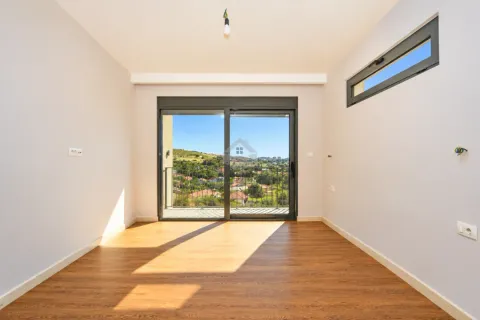 Empty room with wooden flooring, large balcony doors, and a nature view. - image 23