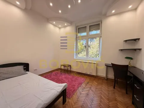 Nameštena spavaća soba sa krevetom, radnim stolom i prozorom. - image 6