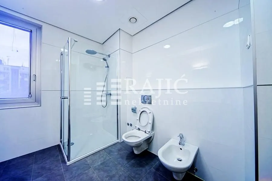 Modern bathroom with a walk-in shower, toilet and bidet.