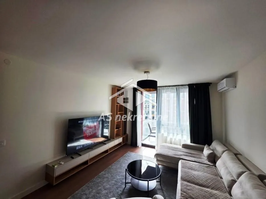 Living room with a sectional sofa, TV, and access to the terrace.