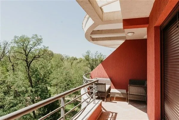 Spacious terrace with outdoor furniture and a green view.
