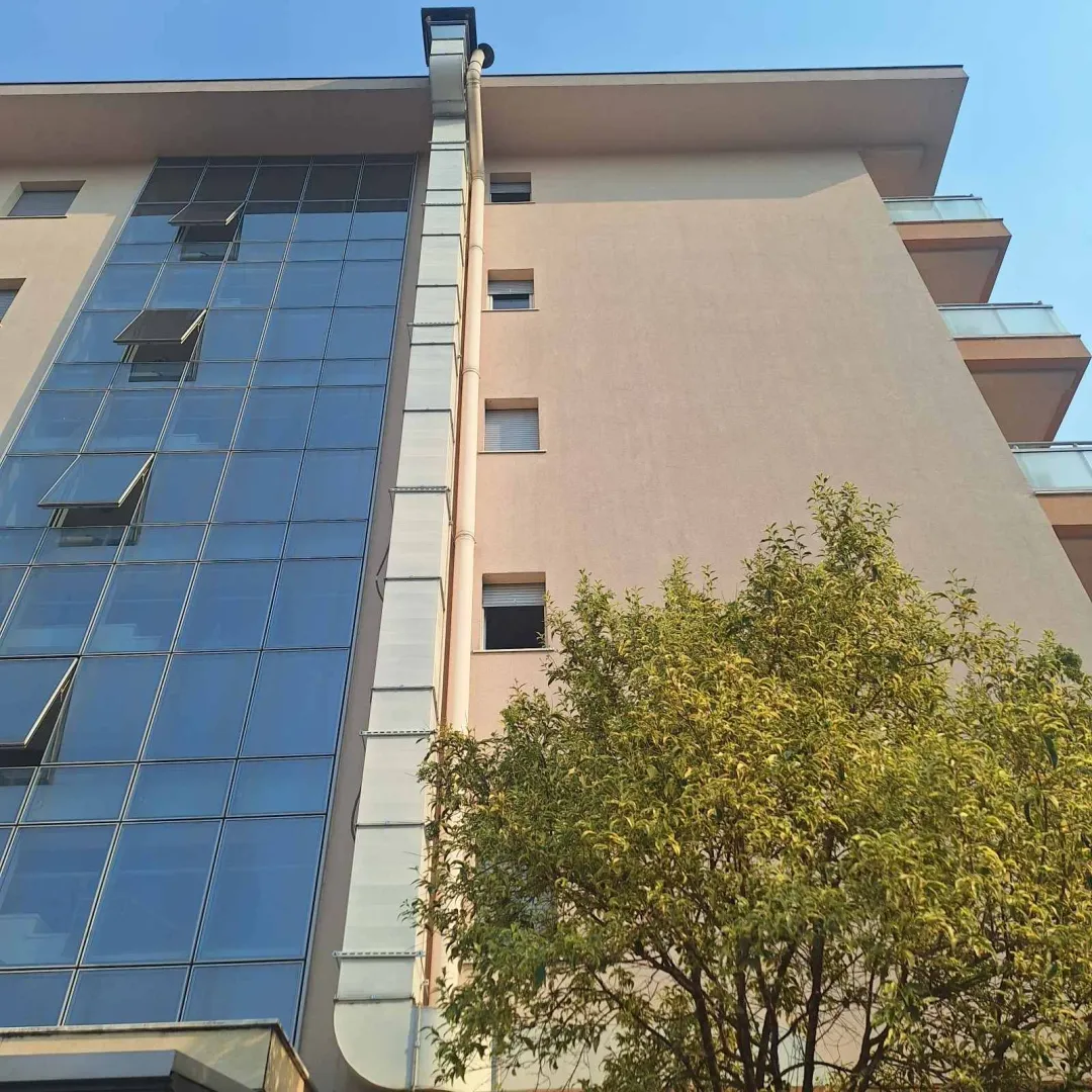 View of the exterior of the building with a glass facade and a balcony.