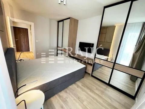 Furnished bedroom with a double bed, wardrobe, and TV. - image 5