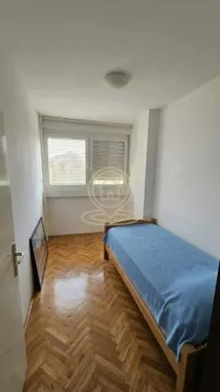 Small bedroom with a bed and parquet flooring. - image 5