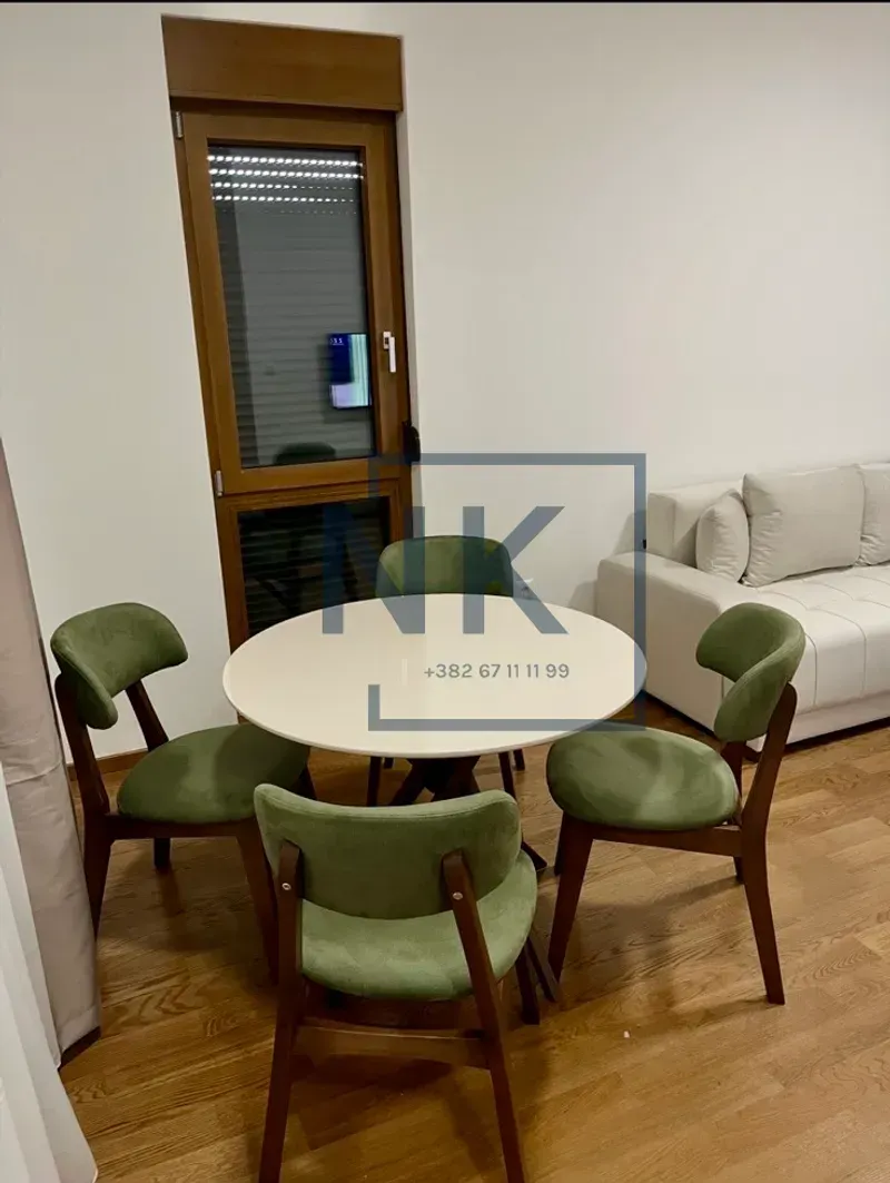 Dining table with green chairs in the living room area.