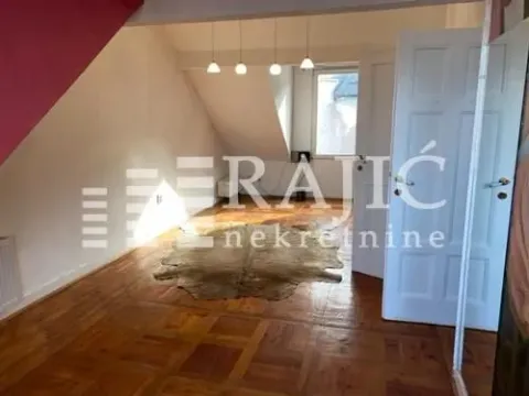 Spacious living room with wooden flooring and a slanted ceiling. - image 4
