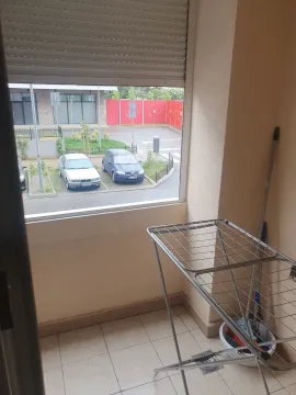 A small balcony with a clothes drying rack and a view of the parking lot. - image 19