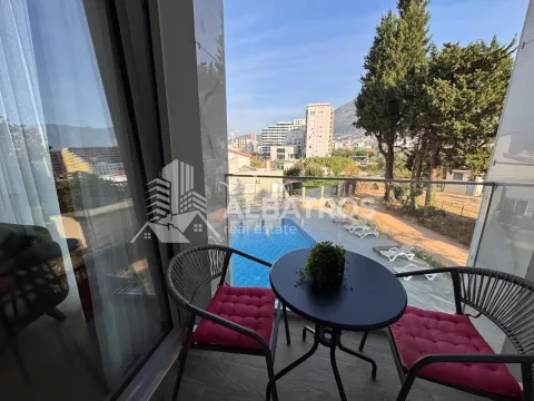A small furnished balcony with a view of the pool and surroundings. - image 15