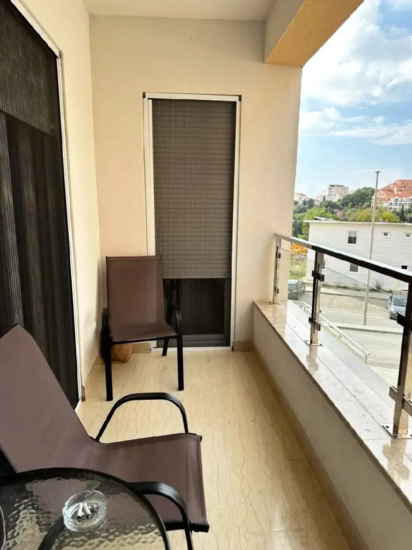 Namtještena terasa sa stolom i stolicama i pogledom na okolinu.