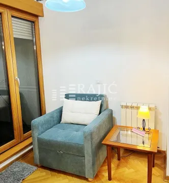 Comfortable armchair and small table in a bright living room. - image 2