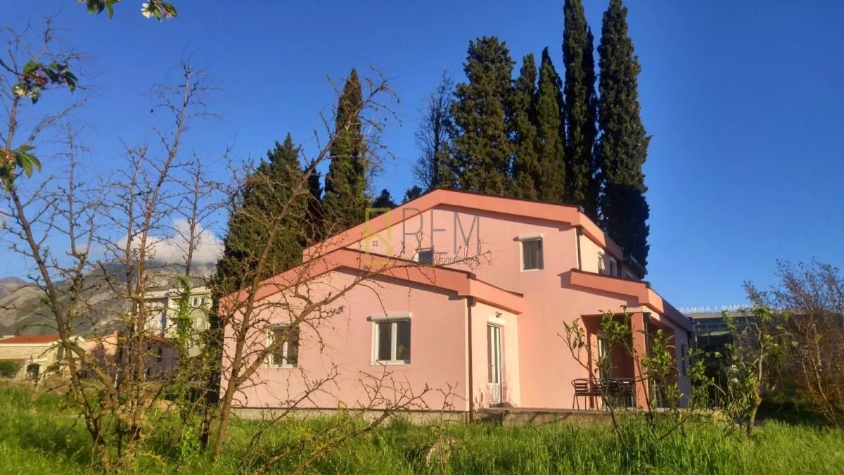 Pogled na spoljašnjost prizemne kuće sa dvorištem i zelenilom.