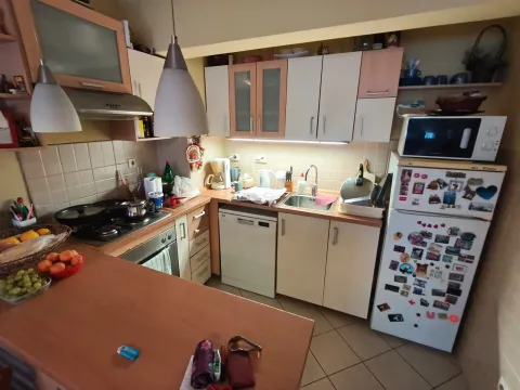 Potpuno opremljena kuhinja sa bijelim elementima i drvenim radnim površinama. - image 6